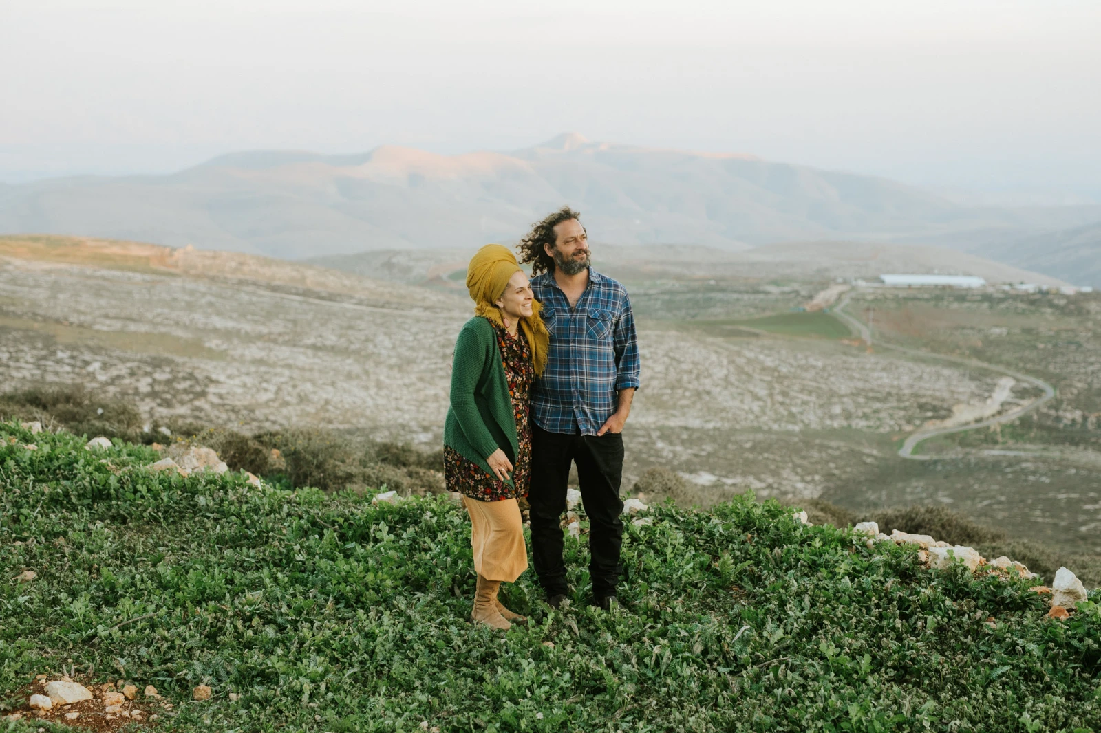 בעלי יקב תום – זוג עומד יחד על רקע הרי השומרון
